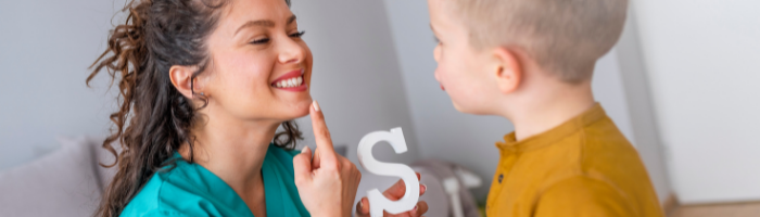 Speech therapist helps child pronounce the letter s
